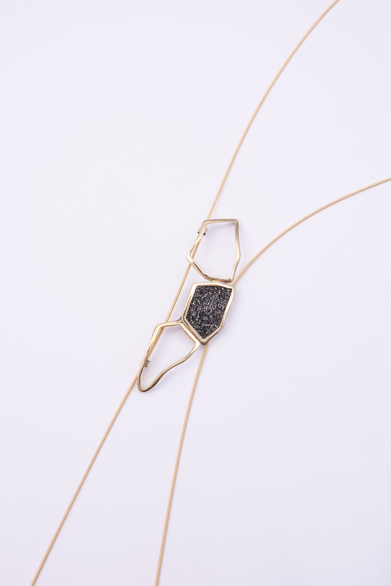 Glow Long Necklace front view: handmade brass geometric statement necklace with faceted crystal centerpiece