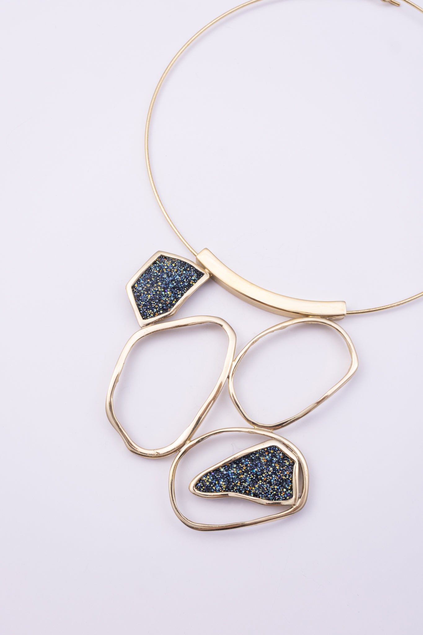 Glow Necklace on white background: handmade brass collar necklace with open organic loops and crystal shards