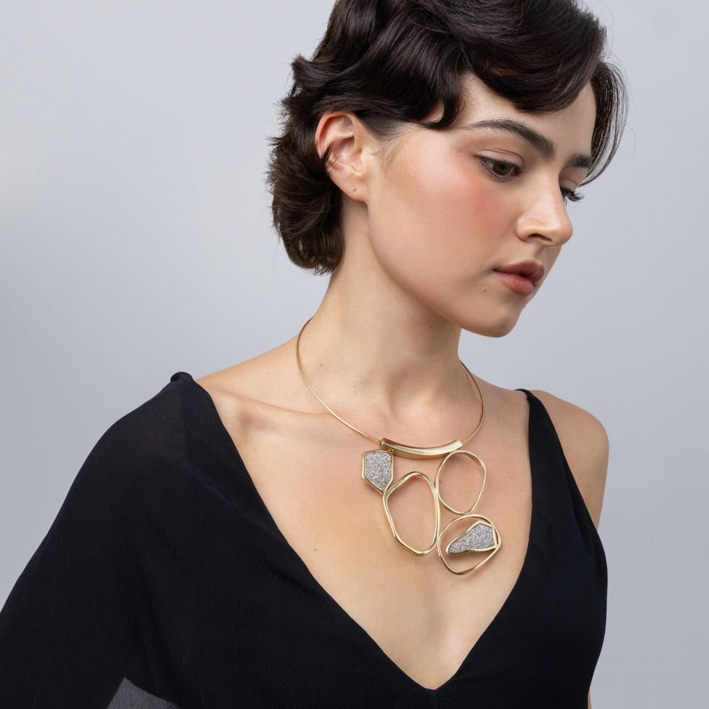 Glow Necklace on model, side look: handmade brass statement necklace with rigid neckwire and crystals