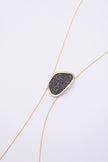 Shimmer Long Necklace close up: handmade brass pendant with tiny faceted crystals in a sleek organic brass frame
