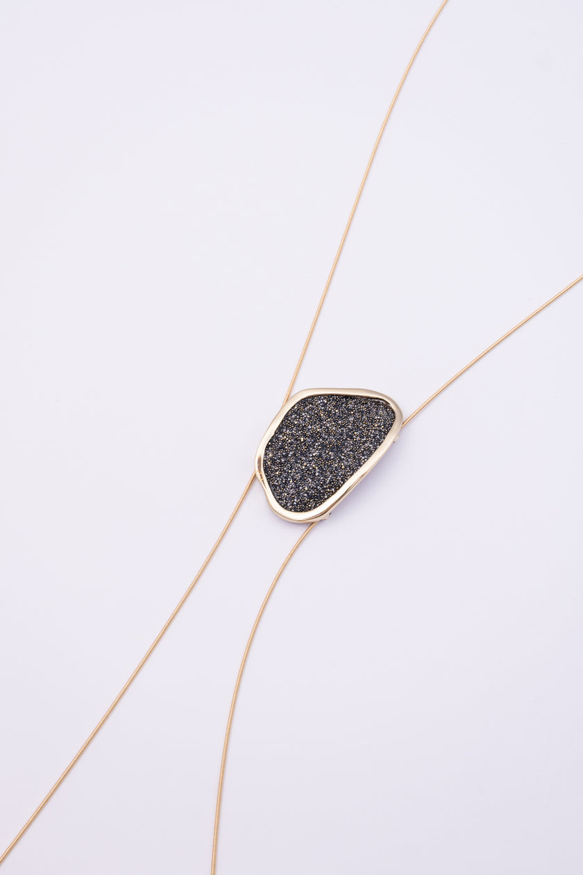 Shimmer Long Necklace close up: handmade brass pendant with tiny faceted crystals in a sleek organic brass frame