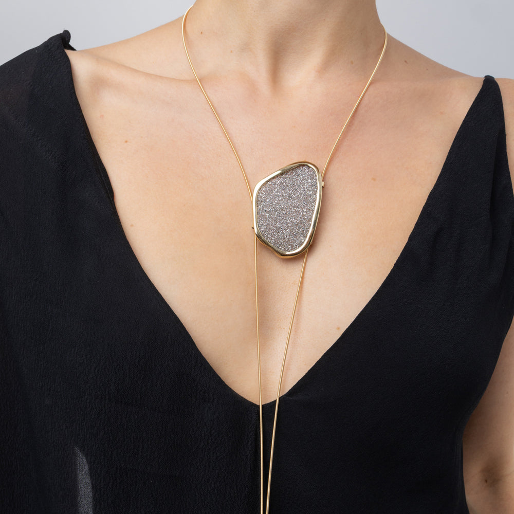Shimmer Long Necklace worn on model: handmade brass long necklace with oval crystal pendant and slim coiled cords
