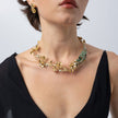 Model wearing the Plume gold-plated floral statement necklace with matching flower earrings, Savage Flora