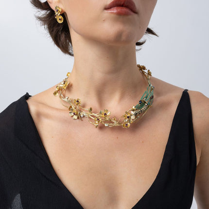 Model wearing the Plume gold-plated floral statement necklace with matching flower earrings, Savage Flora