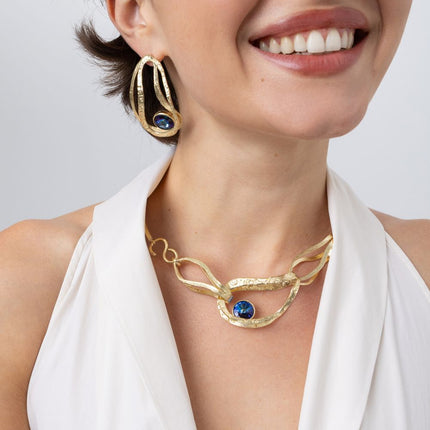 Close-up of the Boteh handmade gold-plated necklace with hammered loops and blue crystal, Savage Flora