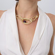 Woman wearing the Boteh gold-plated paisley statement necklace with sculptural textured loops and a purple amethyst-colored crystal, Savage Flora