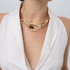 Woman wearing the Boteh gold-plated paisley statement necklace with sculptural textured loops and a purple amethyst-colored crystal, Savage Flora