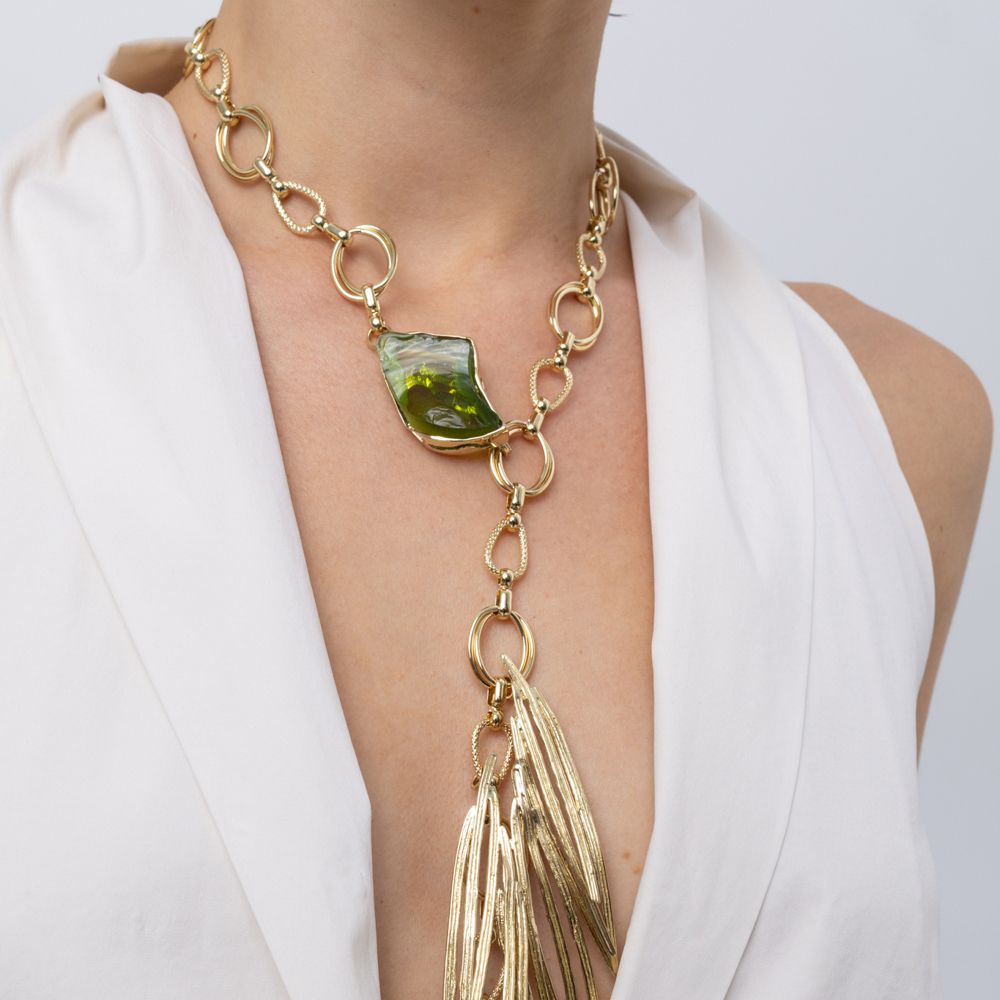 Woman wearing the Kite gold-plated Y-necklace with chunky chain, olive green resin stone and needle-like pendant, Savage Flora