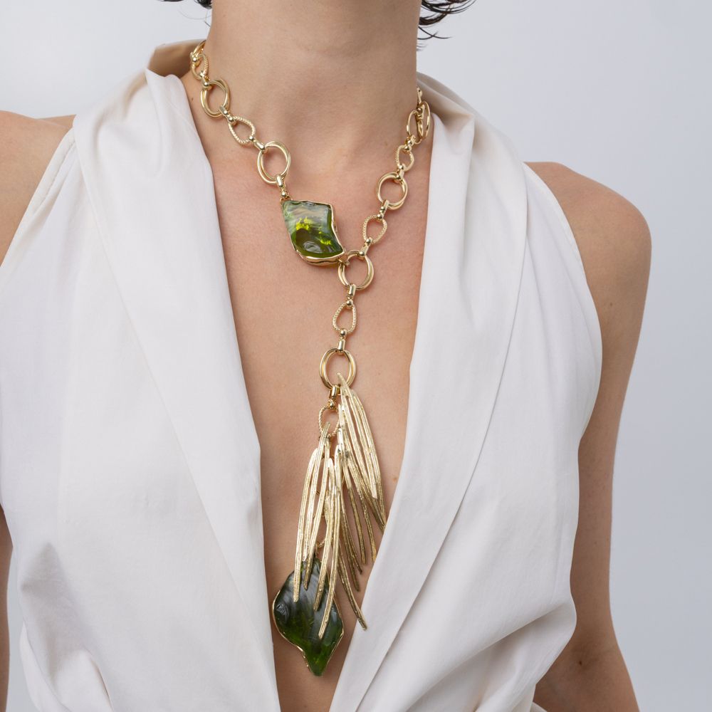 Model wearing the Kite long statement necklace with olive green resin stones and gold needle-like blades pendant, Savage Flora