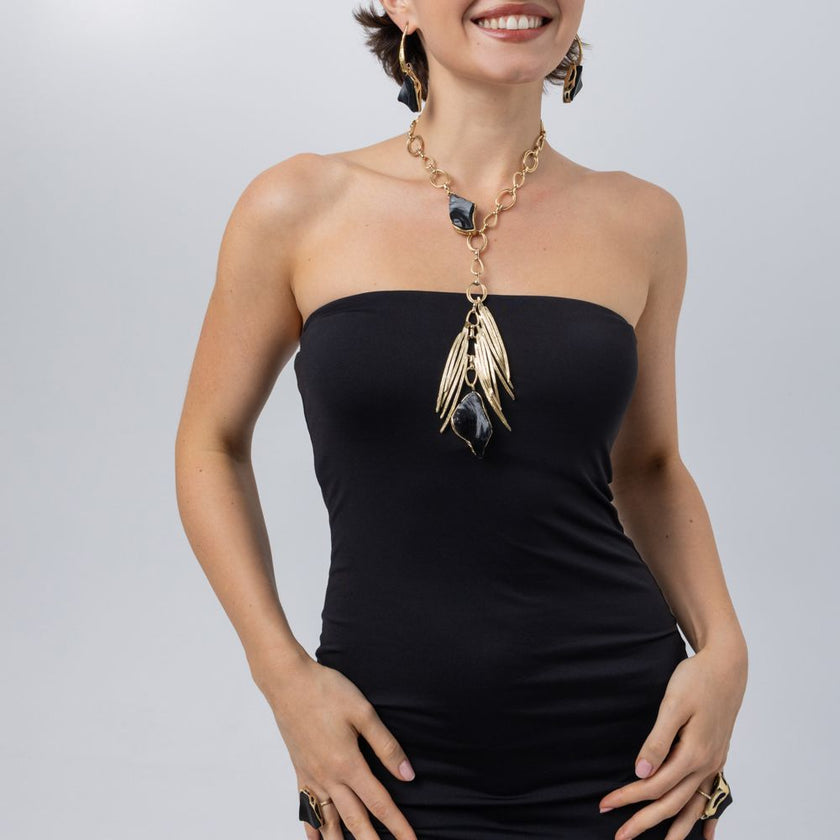 Model wearing the Kite black resin statement necklace with matching earrings and rings, Savage Flora