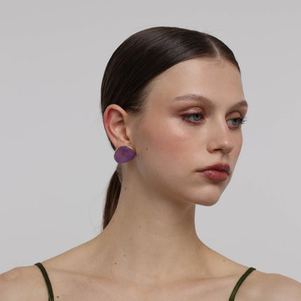 Stoneveil Earrings close-up — handmade brass frame holding a smooth raw resin stone