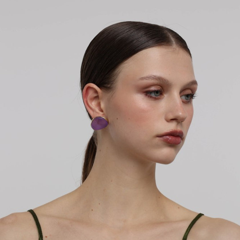 Stoneveil Earrings close-up — handmade brass frame holding a smooth raw resin stone