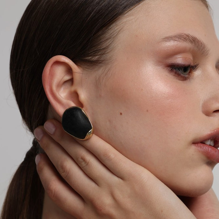 Stoneveil Earrings angle view — handmade brass sculptural stud earrings with oversized stone centerpiece