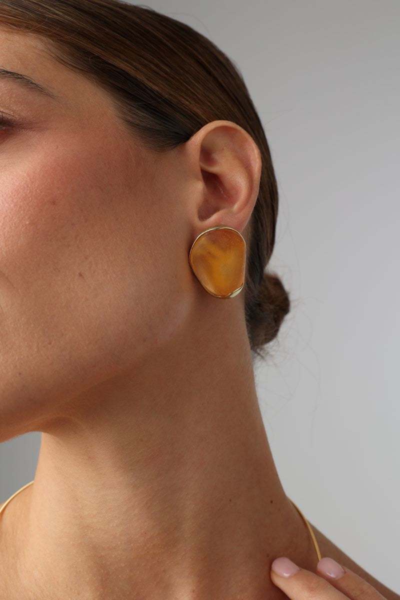 Stoneveil Earrings detail — handmade brass earring with open edge and raw resin stone setting