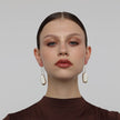 Earthpulse Earrings on model — handmade brass drop earrings worn showing scale and proportion