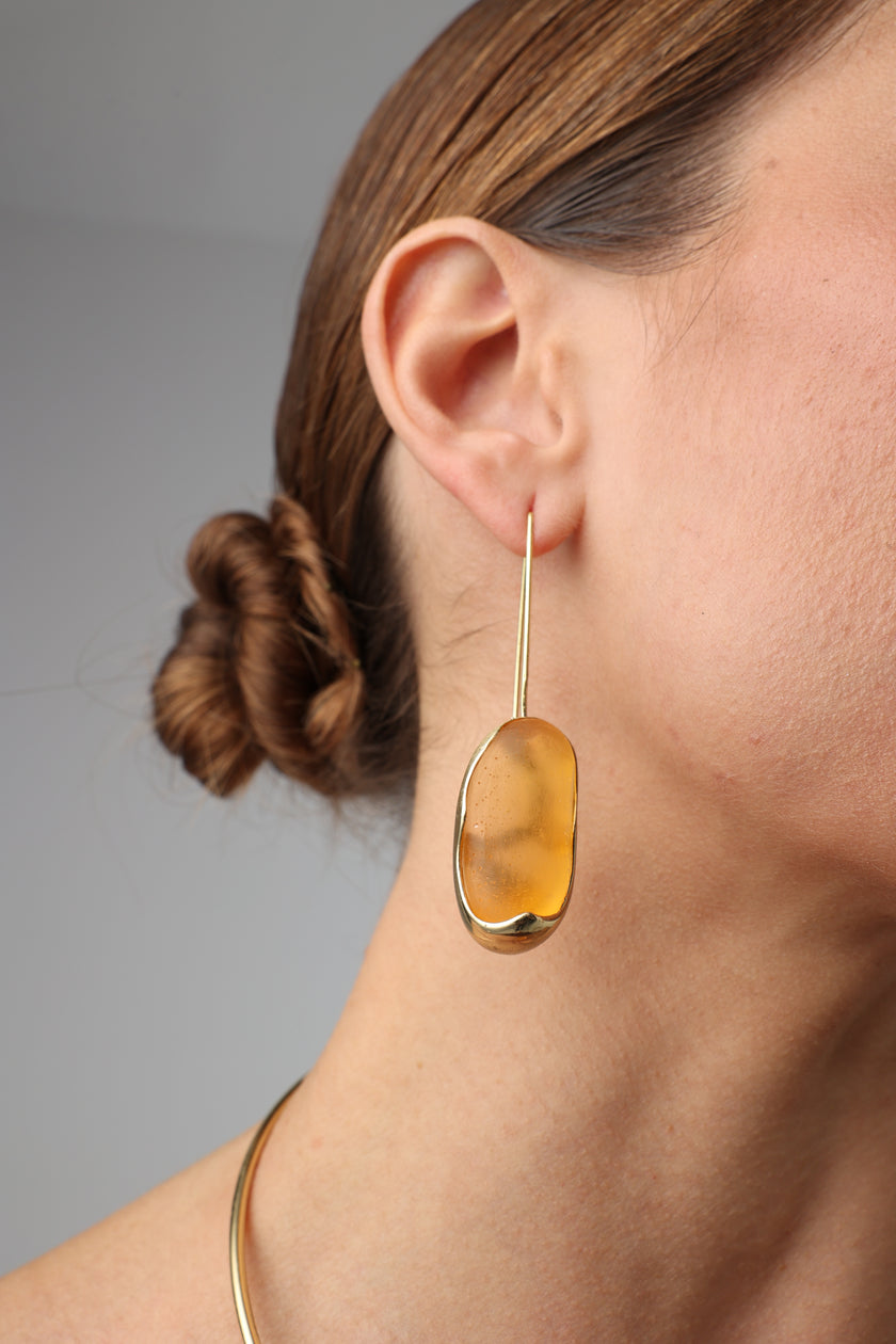 Earthpulse Earrings close-up — handmade brass earrings with organic resin stone worn