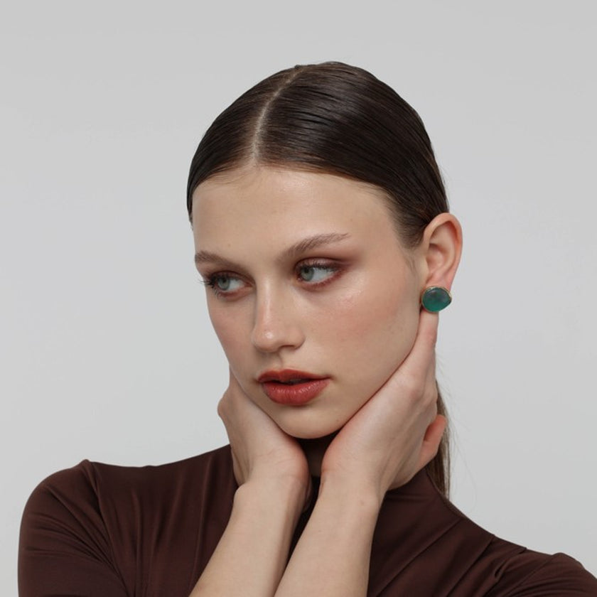 Stonekiss Kiss Button Earrings on model — handmade brass button earrings worn on ear showing scale