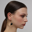 Kiss Hoop Earrings angle view — handmade brass sculptural hoop earrings with rounded stone accent