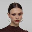 Kiss Hoop Earrings — handmade brass hoop earrings with round resin stone accent on model