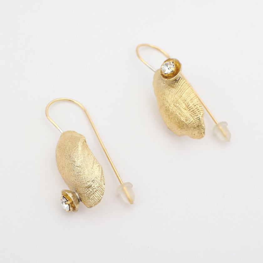 Limpet Earring — handmade brass limpet shell drop earrings with clear crystal on long pin wire, flat lay