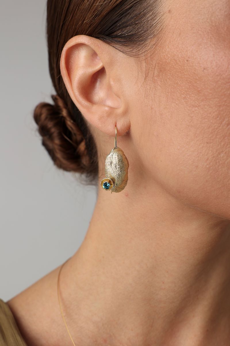  Limpet Earring — handmade brass limpet shell drop earrings with teal crystal on model, close-up