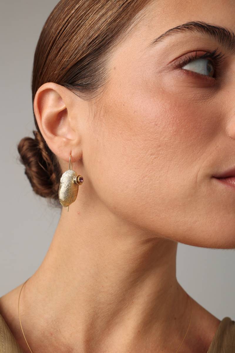 Limpet Earring — handmade brass limpet shell drop earrings with pink crystal on model, close-up