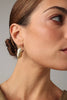 Limpet Earring — handmade brass limpet shell drop earrings with pink crystal on model, close-up