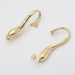  handmade brass sculptural dolphin hoop earrings, flat lay side view