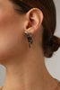 Dragonfish Earring — handmade brass sculptural stud earrings with oxidized raw texture on model