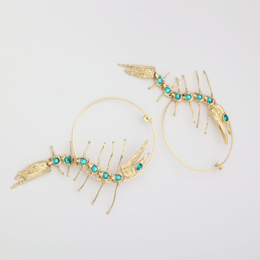Draco Earring — handmade brass statement hoop earrings with sculptural creature and gemstone spine, flat lay