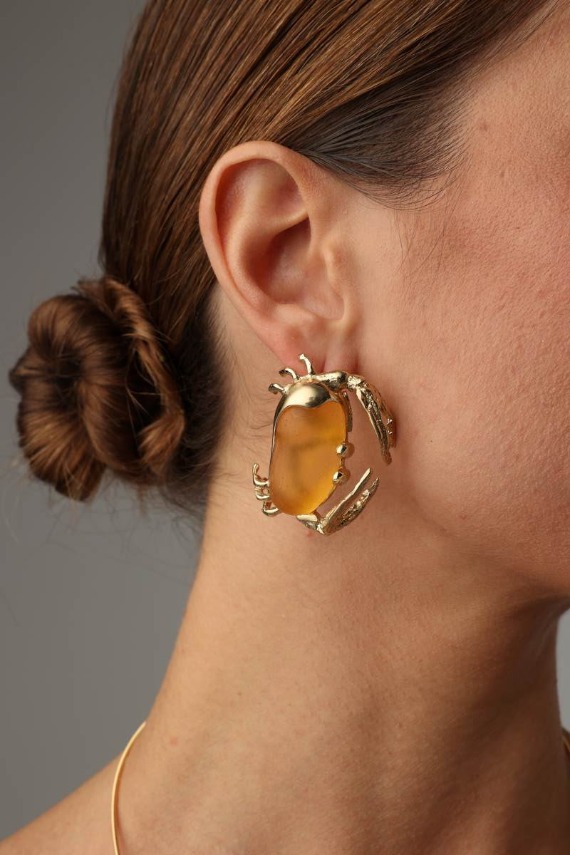 Crabby Earring — handmade brass crab earrings with amber stone body on model, bold statement artisan jewelry