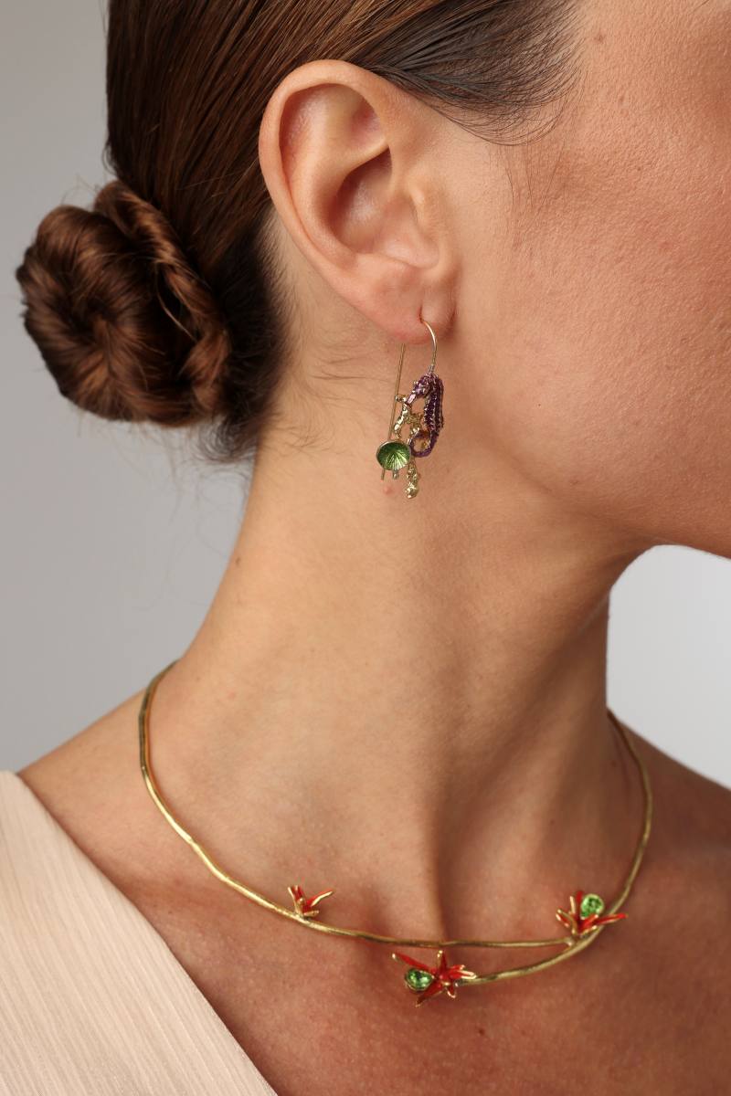 Coralia Earring — handmade brass seahorse and coral drop earrings on model, styled with statement necklace