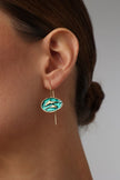 handmade brass enamel drop earrings with dolphin motif oval disc on model, artisan jewelry made in Greece