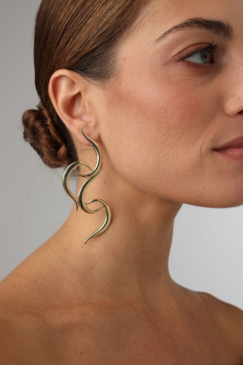 handmade brass sculptural double wave earrings on model, side profile view