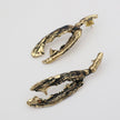 Pair of gold and black textured earrings on a light gray background