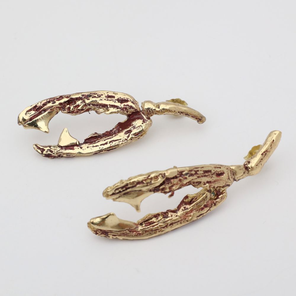 Gold antler-shaped earrings on a light gray background