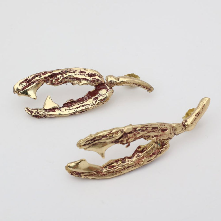 Gold antler-shaped earrings on a light gray background