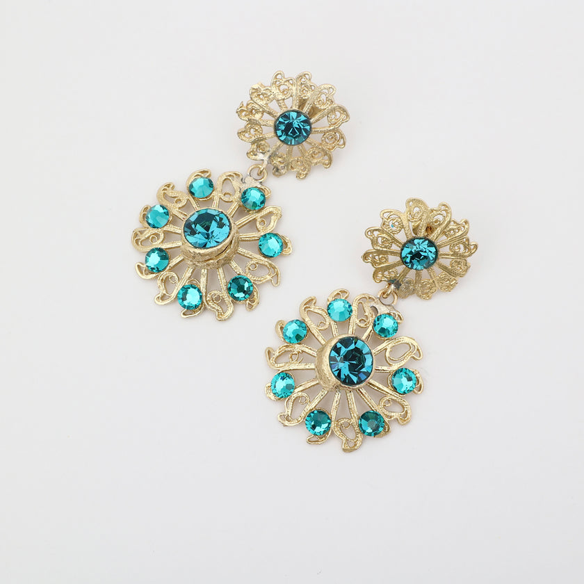 Gold earrings with blue gemstones on a white background
