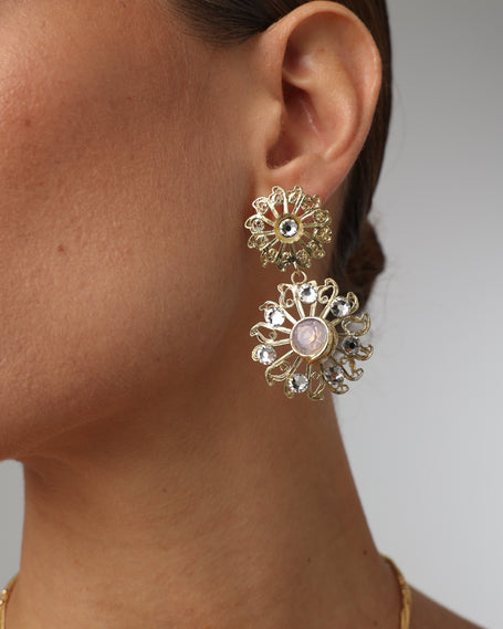 Product shot of luxurious brass filigree earrings on white background.