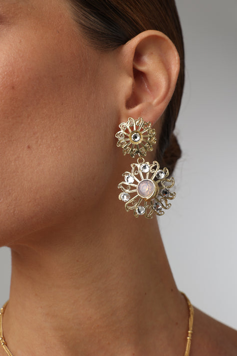 Product shot of luxurious brass filigree earrings on white background.