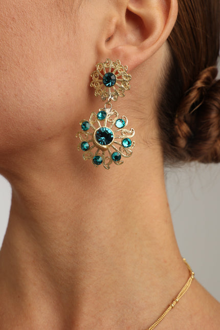  Elegant model wearing handmade Greek brass drop earrings with blue crystals.