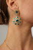  Elegant model wearing handmade Greek brass drop earrings with blue crystals.