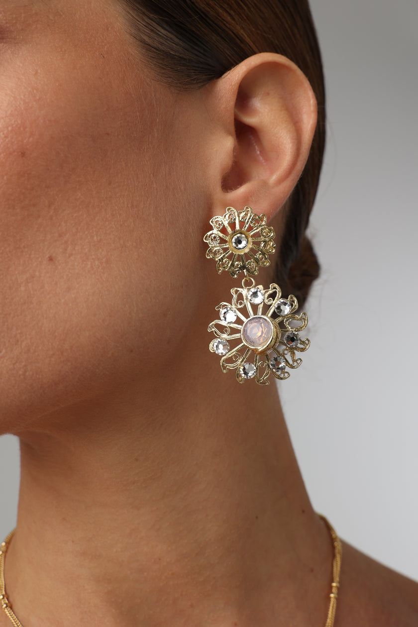 Product shot of luxurious brass filigree earrings on white background.