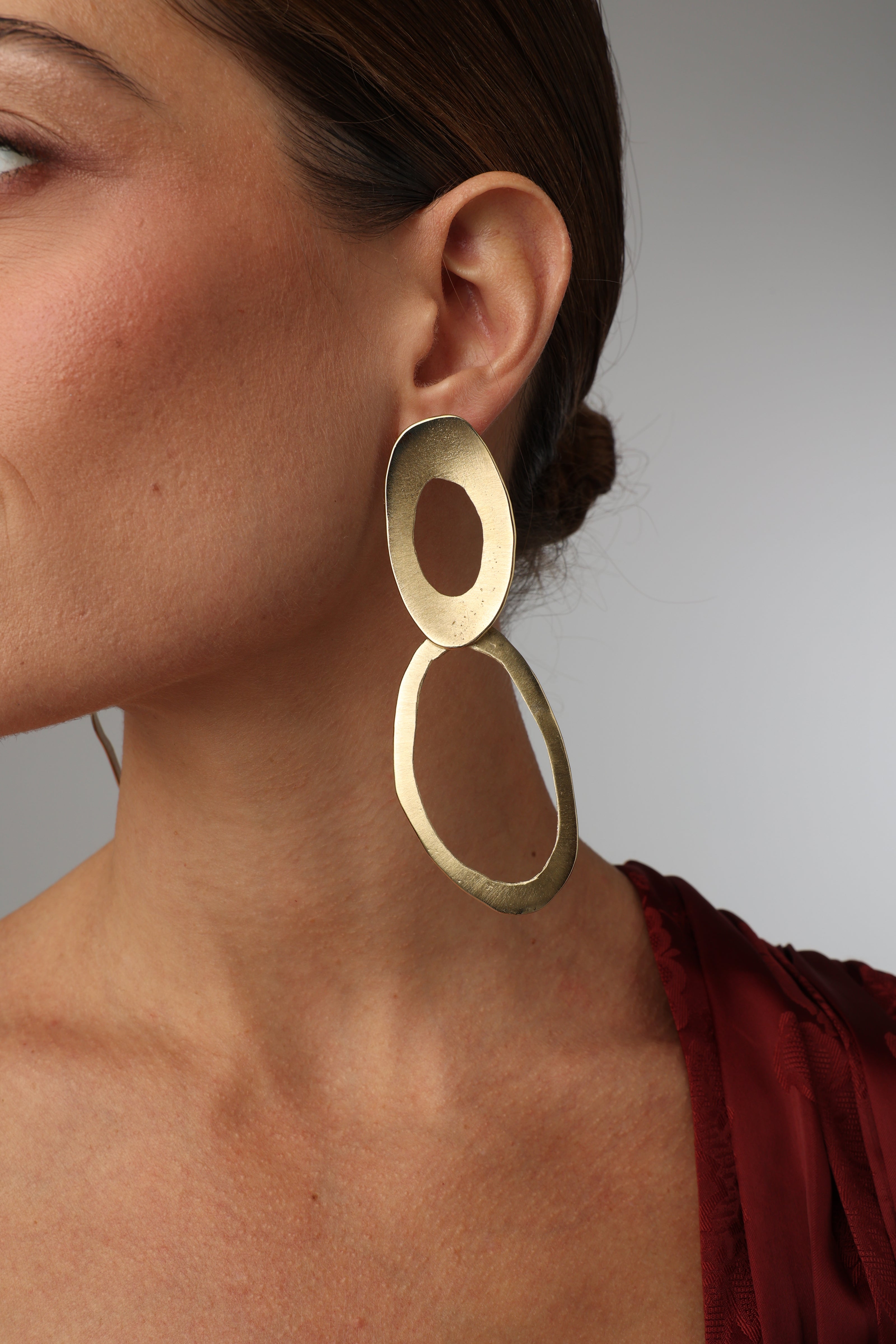 geometric handmade gold-plated drop earrings on model