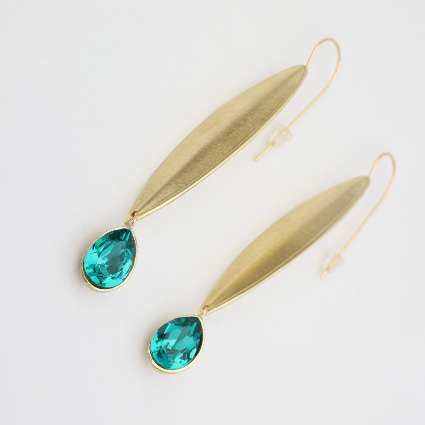 Gold earrings with teal gemstones on a white background