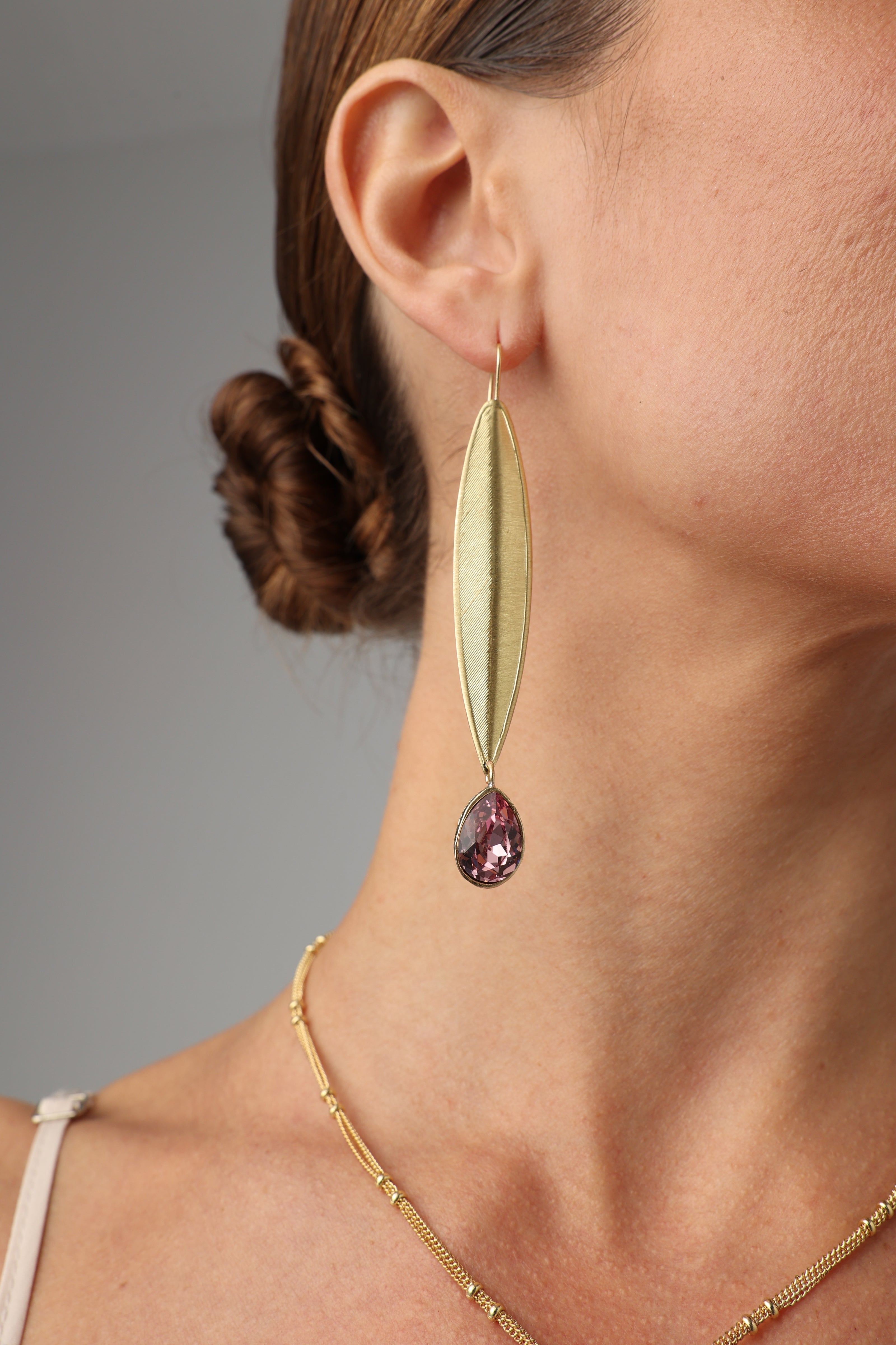 long gold-plated earrings with pink crystal on model