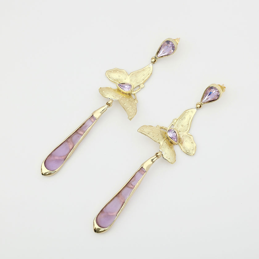 Pair of handmade bronze butterfly earrings with pink crystals and pearls on a white background.