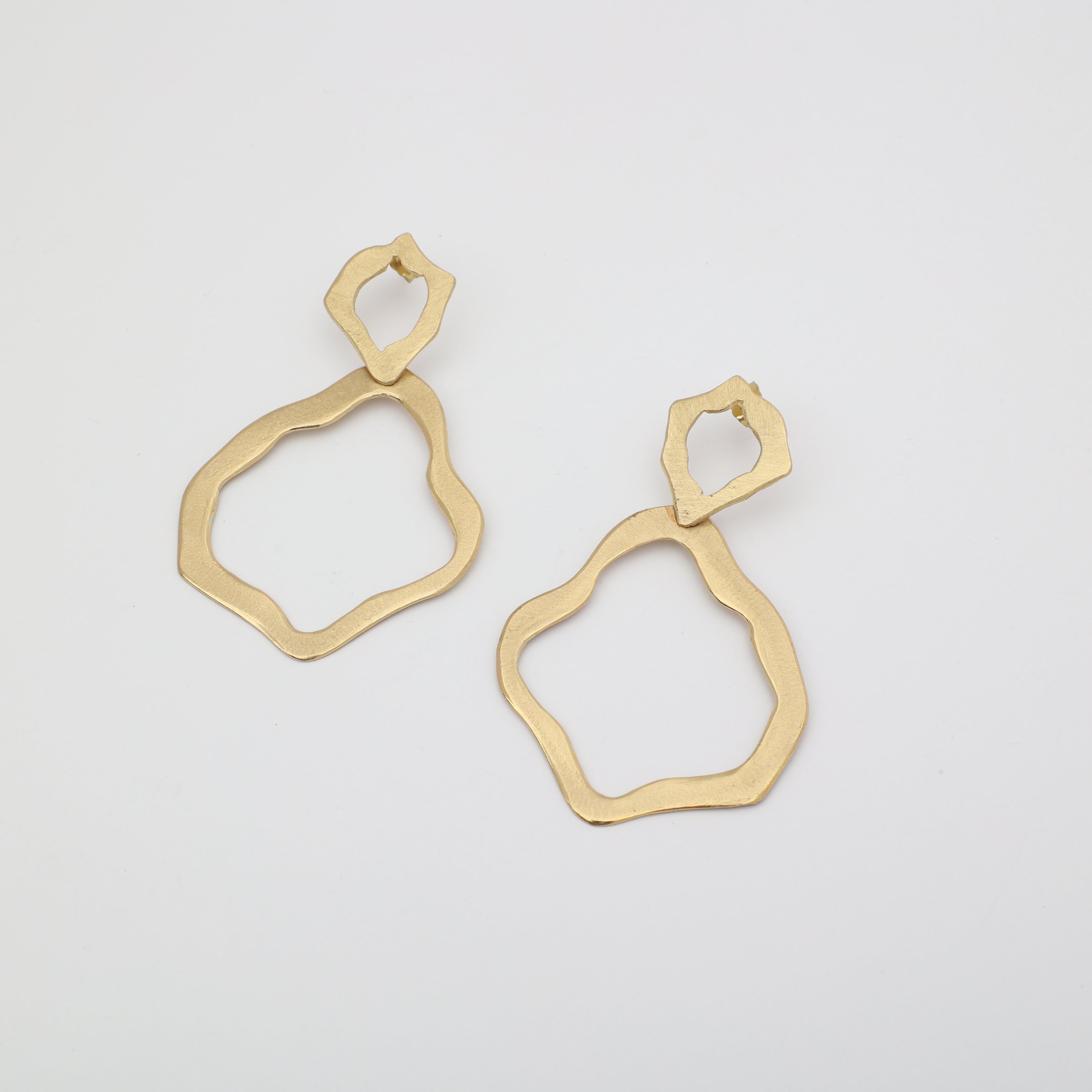 Pair of handmade brushed bronze earrings with abstract organic shapes on a white background.