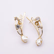 Brass branch-shaped earrings pair with crystal and pearl detail, product shot