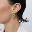 Brass flower stud earring with clear crystal and pearl drop, worn on ear
